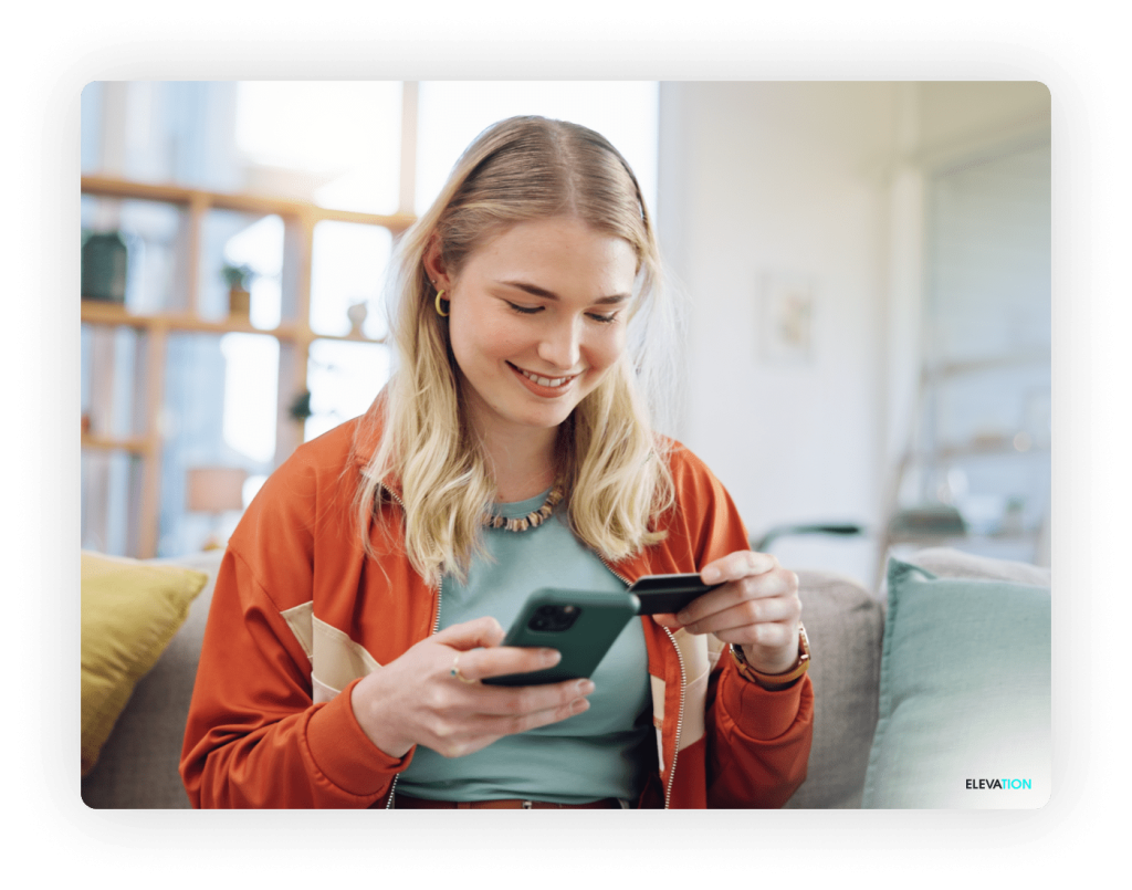Elevation Female holding credit card and mobile device