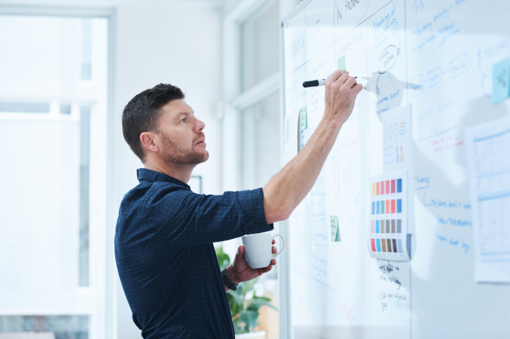 Man writing ideas on a blackboard
